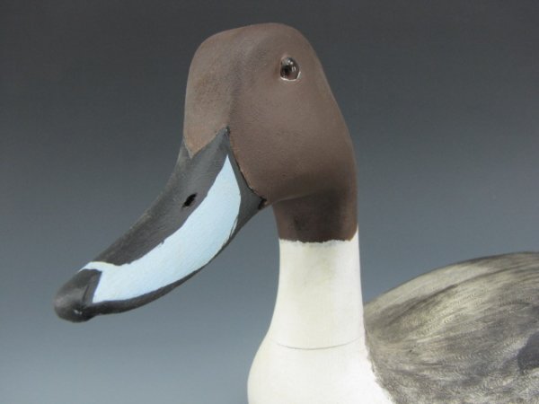 CONTEMPORARY PIN TAIL DUCK DECOY: L.T. WARD: Signed Larry Ward 1983 in ballpoint to bottom, wood burned "L.T. Ward Maker" as well. Glass eyes, carefully etched and painted body, long delicate tail feathering. Measures 20 inches overall.