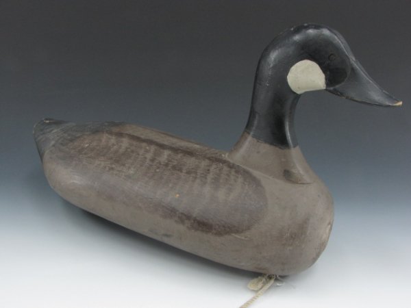 CARVED WOOD CANADIAN GOOSE DECOY ATTR. P. GIBSON: Handwritten attribution of "Paul Gibson, 1902-1985" to bottom, painted eyes and detail, weighted keel, measures 12 x 21 inches.