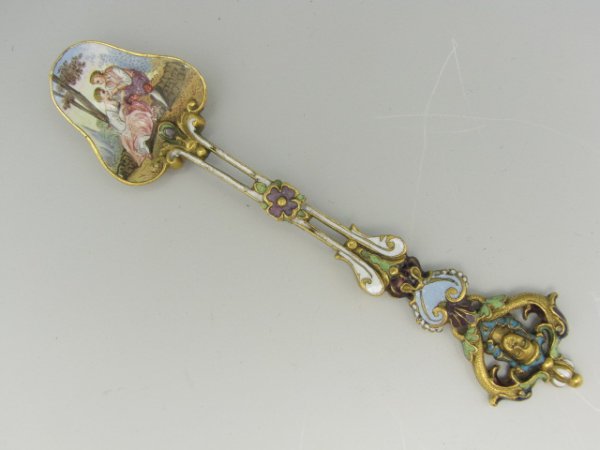 A 19TH C. CONTINENTAL GILT AND ENAMEL SPOON: Romantic scene painted in cloverleaf-shaped bowl, gilt metal base with enamel detailed shaft. Measures 5.25 inches.