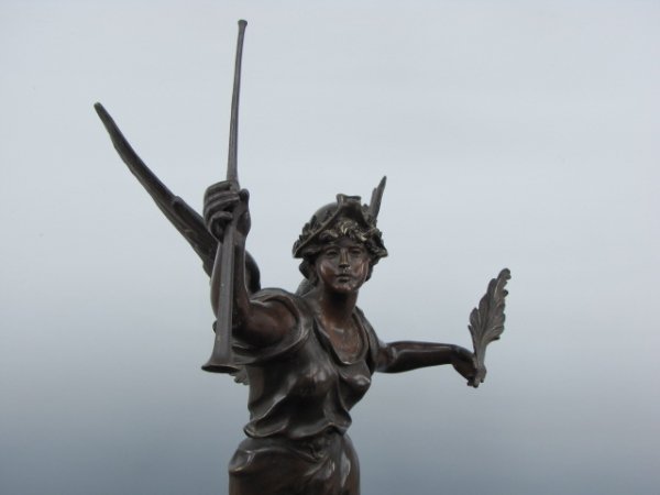MARCEL DEBUT (1865-1933) BRONZE SCULPTURE: Marcel Debut, French, (1865-1933), winged figure wearing a helmet and carrying an upraised trumpet and palm leaf. One leg standing on a small upraised patch on an otherwise smooth hemispheric base. Si