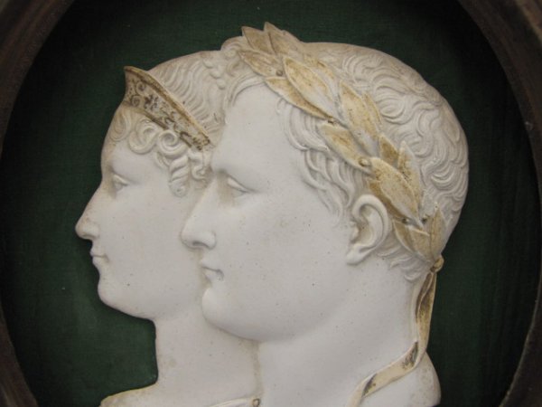 A LAUREATE BUST OF NAPOLEON AND JOSEPHINE: White profile of Napoleon as Caesar, with hand tinted laurel crown, and Josephine with tiara, green cloth background and a fine period satin wood frame with line inlay and bronze bezel. The relief mea