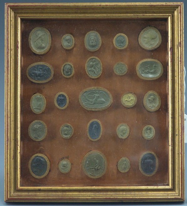 TWENTY-FIVE GRAND TOUR PLASTER INTAGLIOS: Twenty-five round and oval mounted intaglios on copper background, with Greek & Roman Gods, Goddesses and themes including images of Athena, Eros Riding a Dolphin, Mercury, and other classical themes.