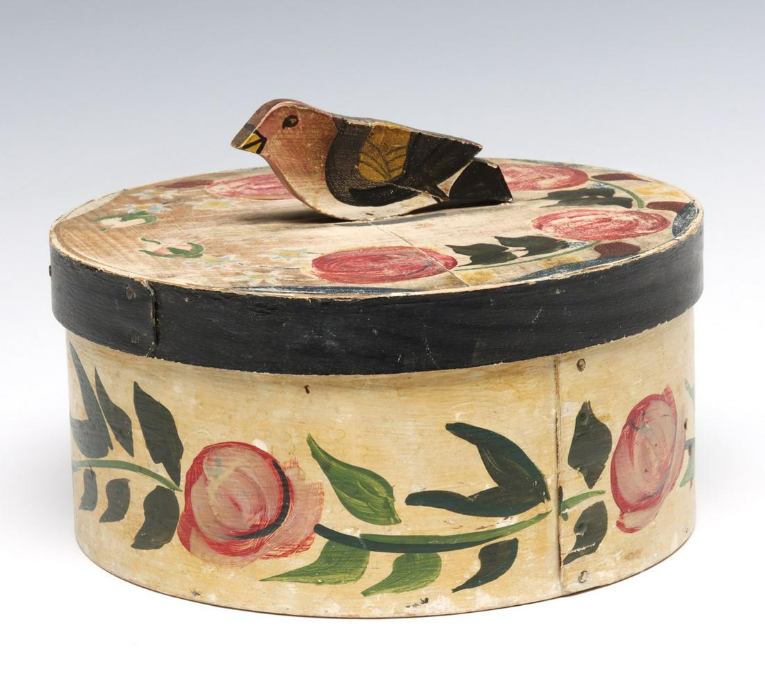 A 20TH C. FOLK ART PANTRY BOX WITH FIGURAL BIRD: The circular bent wood box with floral decoration and the scroll cut wood figure of a bird as handle on the cover. Measures 6.5 x 9.5 inches. We happily provide seamless in-house packing and shipping 