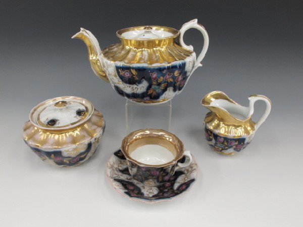 A 19TH CENTURY RUSSIAN (attributed) TEA SET: Includes Teapot with cover, sugar with cover, creamer, and six cups and saucers, plus one extra saucer. Each with a blue underglaze signature mark to bottom. Teapot measures 5 x 9 inches; sugar 4 inch