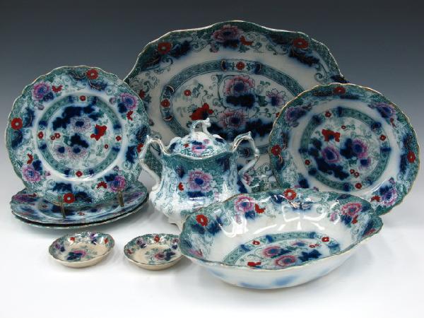 VERONA FLOW BLUE CHINA SET BY WOOD & SON: Includes the platter, 10.5 x 14.25 inches; a 2 x 10 x 7.25 inch oval vegetable bowl; 7.75 inch bowl; three 7.75 inch plates; sugar bowl with lid, measures 6 x 6.5 x 5 inches; plus two 3 inch butter pa