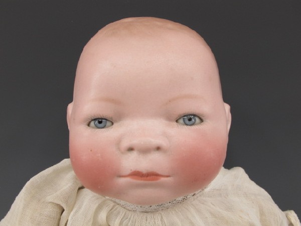 GRACE PUTNAM BYE-LOW BISQUE HEAD DOLL: Fixed blue eyes, old dress, celluloid hands, 14 inches high, signed to back of head.