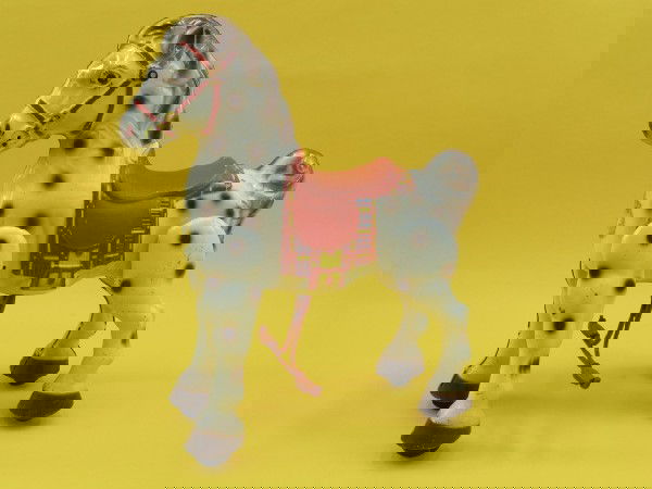 MOBO BRONCO STEEL CHILD'S RIDING HORSE TOY: Painted steel horse with 'Mobo' embossed stirrups, red crinkle finish saddle, rolling hooves and 'riding action,' wooden handles through head, remnant original Mobo decal to front chest. Measures 30.5