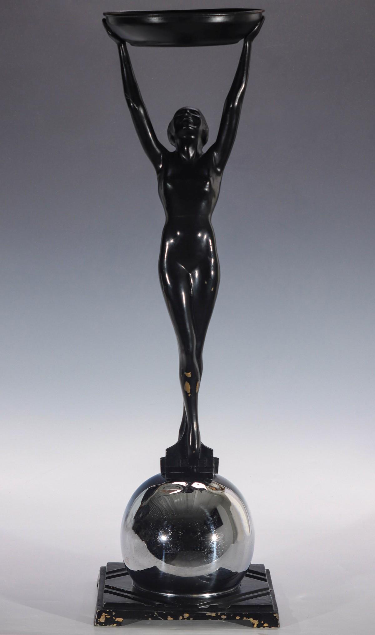 A FRANKART ART DECO ASH RECEIVER WITH FIGURAL NUDE: The design by Arthur von Frankenberg (1889 - 1950) for Frankart featuring a female nude with one foot in front of the other atop a chromed orb on geometric base holding a shallow receptacle high above