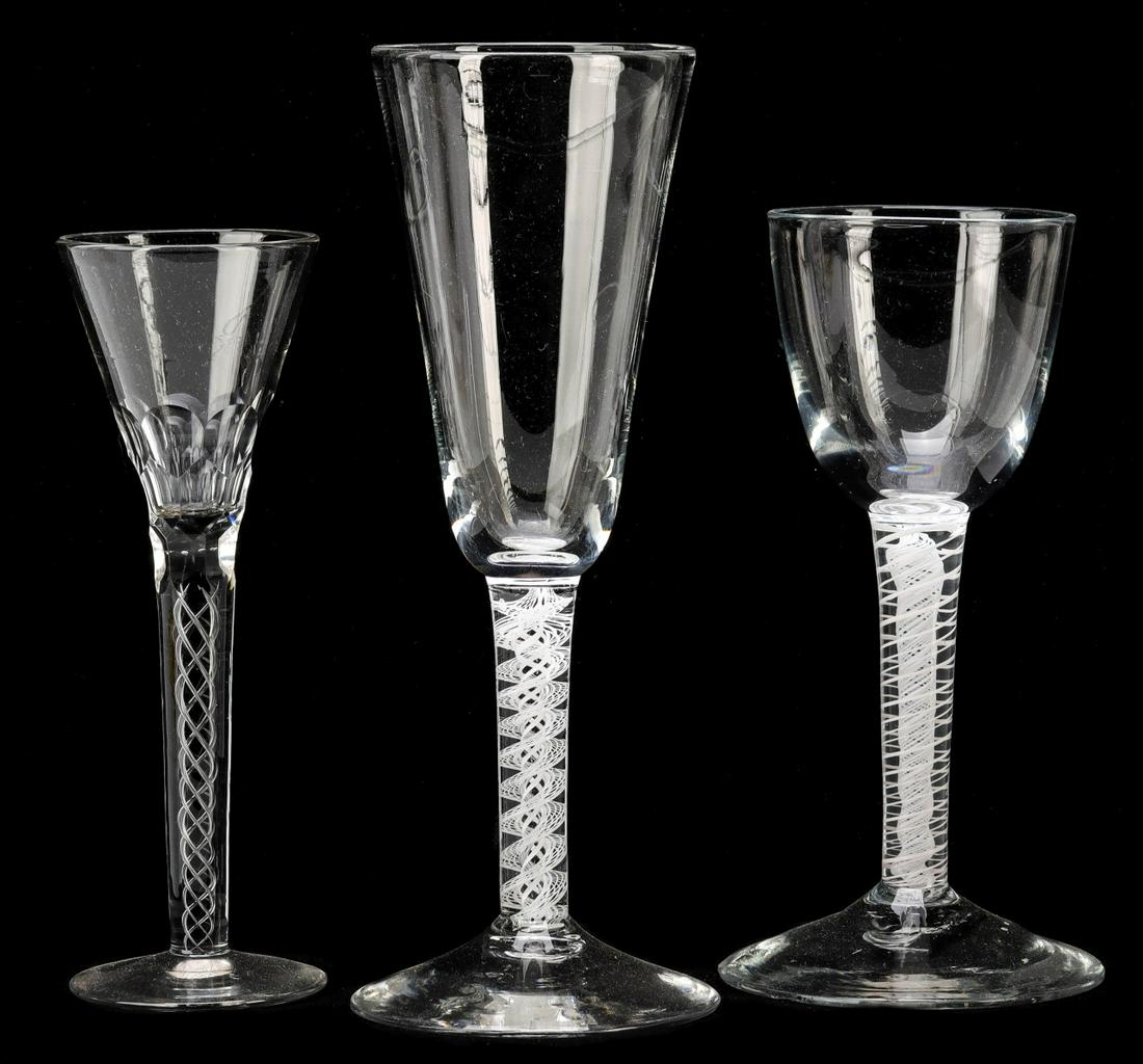 THREE 18TH C. GEORGIAN AIR TWIST WINE GOBLETS: The three very different examples with clear bowls on stems with internal air twist latticinio type decoration, the smallest example with two rows of cut panels on the bowl. Measures 7 x 2.75, 6 x 3, 