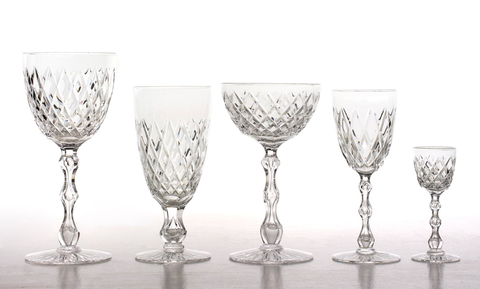 FORTY-ONE PIECES OF SENECA CRYSTAL PATTERN 1939: The cut and polished crystal piece types with faceted stem centered by an internal teardrop bubble include twelve 8-inch wine glasses; eight 4.25-inch cordials; nine 6.75-inch vintage champagne glasse