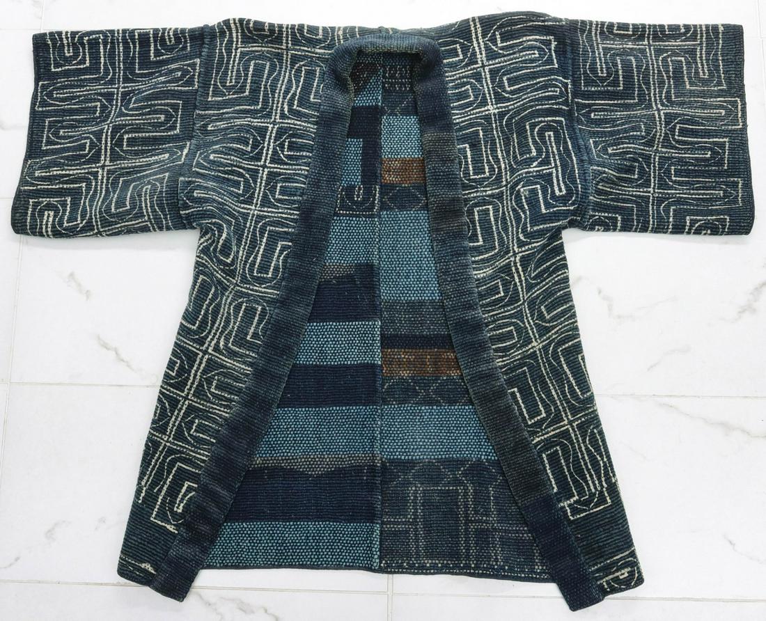 A MEIJI PERIOD JAPANESE FARMER'S COAT OF LOOMED FABRIC: The loomed and painted Sakiori farmers coat with wide indigo lapel, painted exterior and interesting interior patterns and colors resulting from the looming of various materials. The display is includ