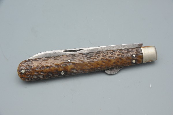 A CHALLENGE CUTLERY LONG SPEAR FOLDING KNIFE: Ricasso marked 'Challenge Cutlery, Bridgeport, Conn.' Measures 3-5/8 inches, 8 inches overall. Double stag grips. Shows age and some sharpening.