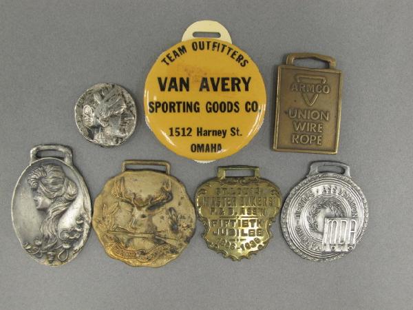 SEVEN ADVERTISING WATCH FOBS & SCOREKEEPER: Includes a Van Avery Sporting Goods Team Outfitters, 1512 Harney St., Omaha' celluloid fob with baseball scorekeeper reverse, fully functional, measures 1.75 inches in diameter, a bit of sticky residu