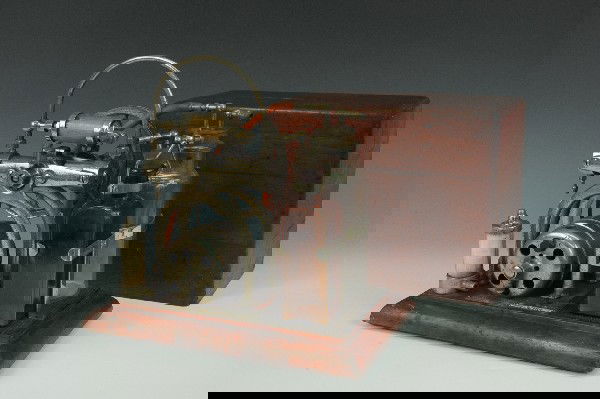 A SORENSEN TANKLESS AIR COMPRESSOR MODEL 60: Rare antique medical air compressor with glass bottles, rubber elements and spec plate, 'C.M. Sorensen Co., Inc., machine no. 18403. On wooden base and with dovetailed wooden cover. Measures 12.5 x 7.