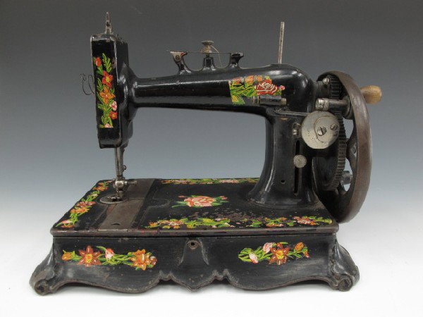 A NEW NATIONAL SEWING MACHINE, CIRCA 1902: Black with full color floral decals, hinged on cast iron base, 11.5 x 13 x 9 inches.