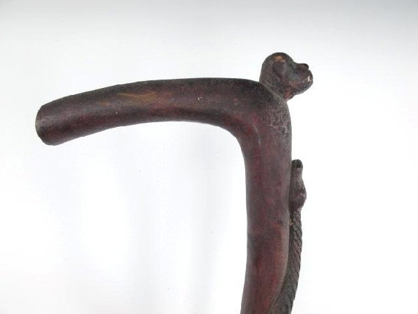 A FOLK ART CANE WITH DETAILED SNAKES AND DOG: A great old cane with dog head finial above two highly detailed snakes complete with defined scales. Original or very old crusty alligatored red stain finish.