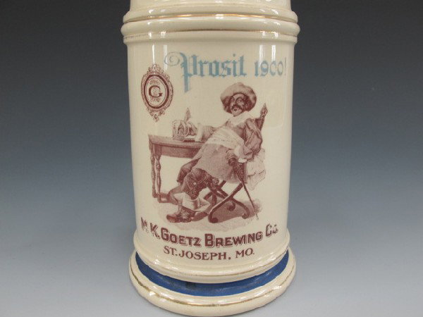 STONEWARE BEER MUG, M.K.GOETZ BREWING CO.: 6" tall, Thuemler mfg co. Pittsburg, Pa. mug reads, Prosit 1900!, M.K. Goetz Brewing co. St. Joseph, Mo. Man sitting at table drinking beer.