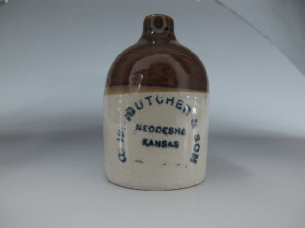 STONEWARE MINI JUG, BUTCHER NEODESHA KANSAS: 3" tall tan bottom brown top blue lettering, reads C.W. Butcher & son Neodesha Kansas.