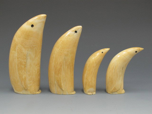AN ALASKAN ESKIMO WHALE IVORY PENGUIN FAMILY: Four sperm whale teeth, subtly carved details, inlaid baleen eyes, very nice honey brown patina, sizes of 6-1/2 inches, 5-3/4 inches, 4-1/2 inches, and 4 inches. No international shipping.