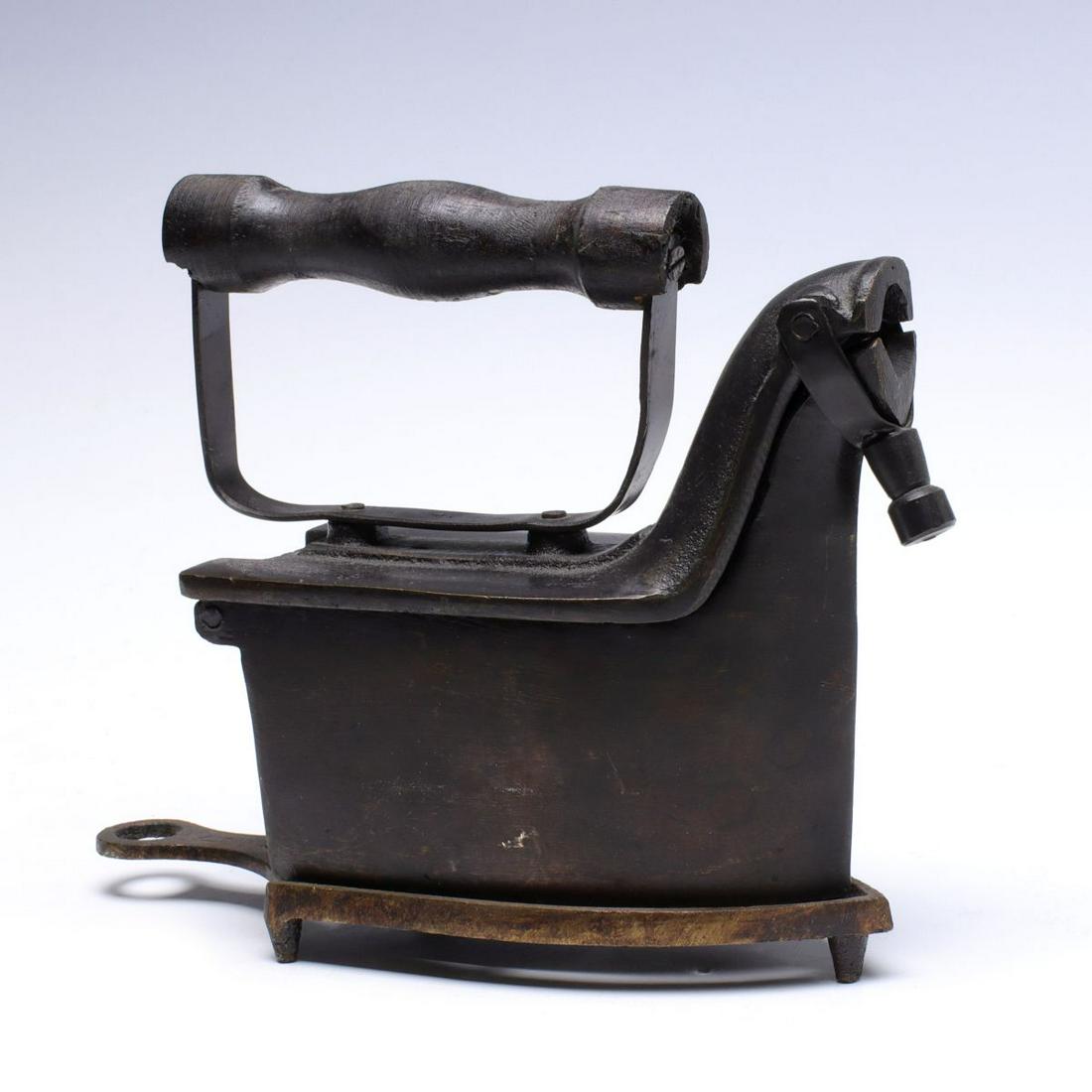 AN ALBA CHARCOAL IRON WITH MATCHING TRIVET: Complete with trivet and grate, signed ALBA on the chimney door and the trivet. Measures 5.5 x 5.5 x 2.25 inches. We happily provide seamless in-house packing and shipping services on nearly everythin