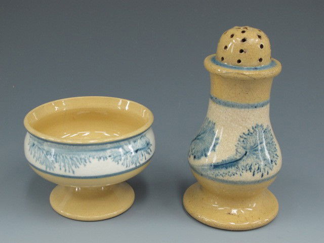 TWO GOOD PIECES OF YELLOWARE WITH SEAWEED DECORATION: Yelloware shaker and a small pedestal salt, both with blue seaweed decoration. Shaker measures 4.5 inches, salt measures 2.25 x 3 inches.