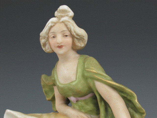 A ROYAL DUX ART NOUVEAU FIGURE: A maiden leaning on large shell basin, signed Royal Dux 817. Measures 8.25 x 5.5 inches.