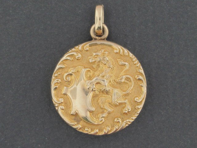 A 14K GOLD LATE VICTORIAN LOCKET: Gold locket with rampant lion and heraldic shield, marked 14K, fantastic condition, measures 1", weight of 9 grams.