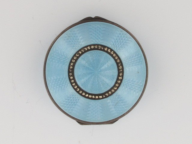 A GUILLOCHE' ENAMEL AND MARCASITE BOX: Gilded interior, mirror inside lid, stamped marks include C & C, engine-turned designs beneath blue enamel, measures 2.75" and weighs 51 grams.