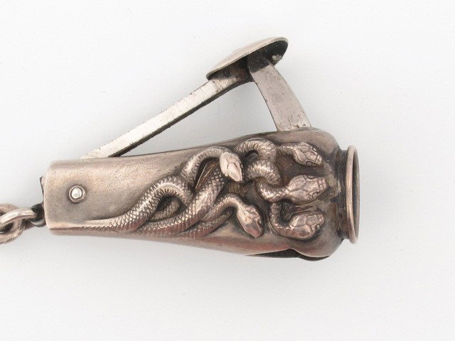 A FINE STERLING SILVER CIGAR CUTTER: Great cutter with embossed snakes marked sterling, measures 1.5".