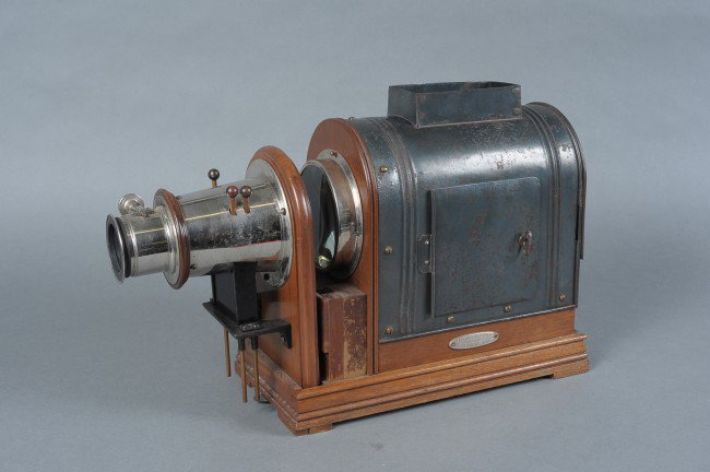 A MAGIC LANTERN BY M.C. LILLEY & CO: Finely constructed from sheet metal and wood, 'The M.C. Lilley & Co, Military and Society Goods, Columbus, Ohio' tag applied to side. Side door, back door, three filter plungers in front of lens for r