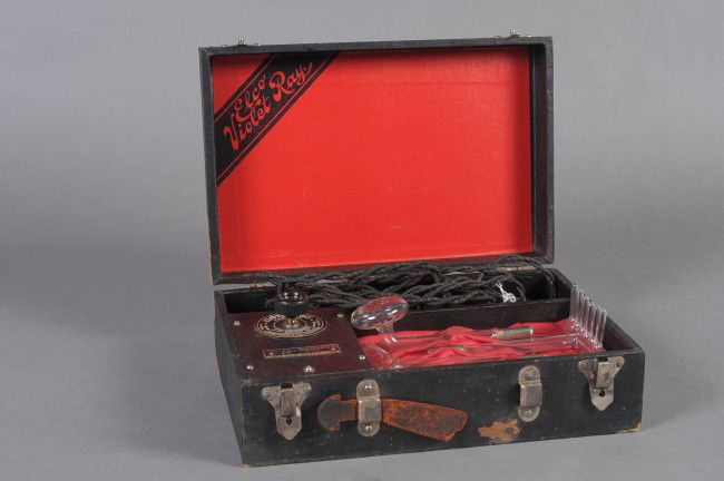 A QUACK MEDICAL ELCO VIOLET RAY KIT: Early 20th century kit with wand, three glass electrodes; cord and plug, Elco company spec plate affixed beneath control knob. Self-contained with hinged lid. Measures 4 x 12 x 8 inches.