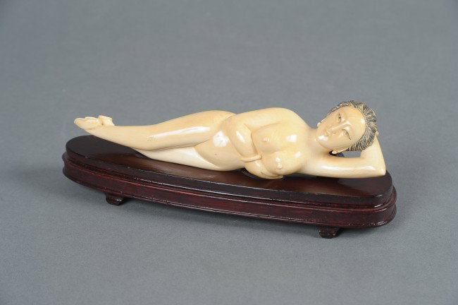 AN ASIAN PHYSICIAN'S CARVED IVORY FEMALE MODEL: Carved ivory reclining female form physician's model, finely carved features, darkened hair, signed on bottom of right shoe. Measures 7.75 inches long. On specially carved wooden bed, 1 x 8 x 2.25 inc