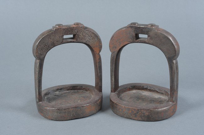 A PAIR OF JAPANESE STIRRUPS WITH BUDDHIST SYMBOLIC DESI: 18th century iron stirrups with inlaid silver designs of symbolic Buddhist meaning including Vajra (thunderbolt) and Manji (reverse Swastika emblematic of good fortune). Measures 6.75" x 5" x 4.25" ea