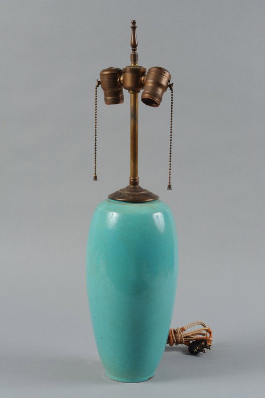 BROADMOOR POTTERY LAMP SIGNED P.H. GENTER: A blue glazed vase form lamp base with factory opening for wiring, weighted and set with period hardware. Scratch signature. Measures 23" x 5".