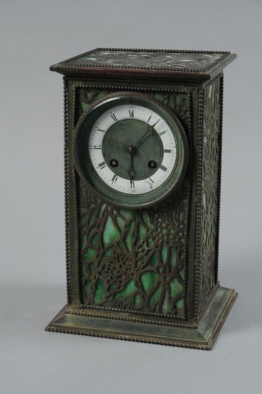 A BRONZE AND SLAG GLASS DESK CLOCK: A grape vine filigree bronze backed by green and white slag glass similar to those made by Tiffany Studios, this unmarked copy example is attributed to Riviere Studios circa 1930's. Patinated bronze a