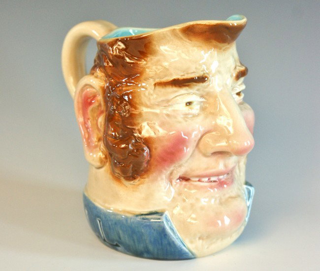 A SARREGUMINES FRENCH MAJOLICA JOHN BULL JUG: Figural jug of classic English character John Bull, with bushy side burns and high collar. Overglazed incised 'Sarreguemines, 3257, 2, 27, 05, B' to bottom. Measures 6.5 x 5 x 6.25 inches.