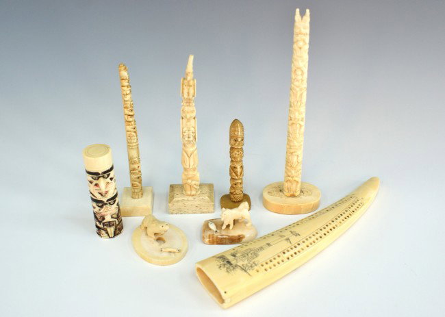 LOT OF 8 PIECES OF ESKIMO CARVED IVORY: Includes a 5.75 x 1.5 inch totem pole; a 5.5 x 1 in pole; a 7 x2 inch pole, 3 x 1 inch pole, and 3.25 x 1 inch pole. Also a 1 x 2 inch carving of a bear and seal on an ice floe, and a 1 x 1.75 inch wo
