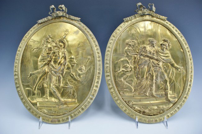 A PAIR OF BRONZE DORE CLASSICAL THEME PLAQUES: Victorian cast bronze plaques, Dore finish, classical scenes in high relief and incised line details. Applied cast ribbons above, measure 16 x 12 inches.