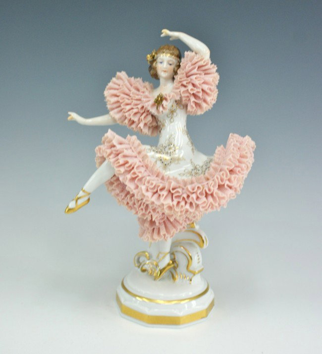 A MULLER & CO ART DECO PERIOD DANCING FIGURE: A woman in flapper style, pink lace ruffled dress and gold painted ballet slippers. Maker marked bottom. Measures 9 x 5.5 inches.