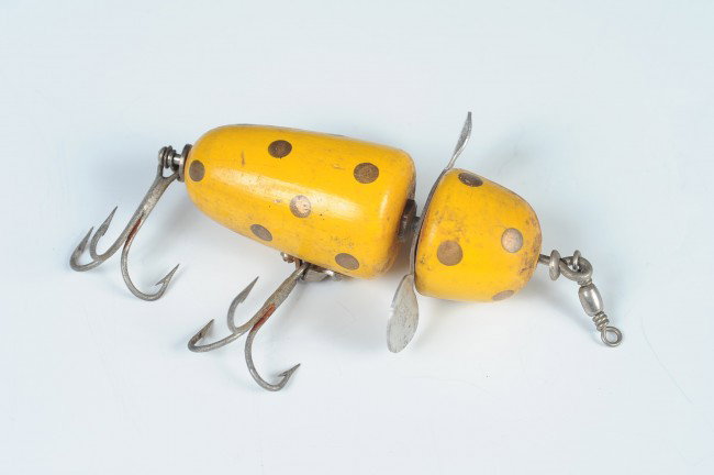 A PFLUEGER GLOBE FISHING LURE: Yellow with gold spots, measures 3.5 inches.
