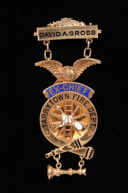 14K GOLD TARRYTOWN FIREMAN EX-CHIEF MEDAL: Pin back brooch with black enamel name 'David A. Gross,' chain suspended medallion with eagle over blue enamel 'Ex-Chief,' and black 'Tarrytown Fire Dept.' Applied firefighter equipment with white ena
