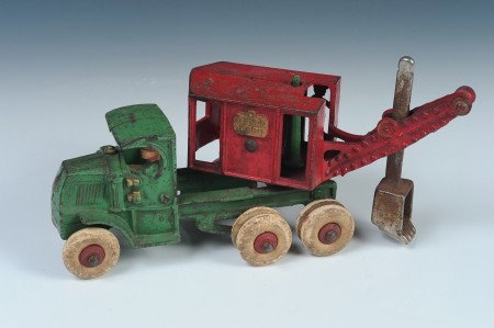 A HUBLEY CAST IRON MACK PANAMA DIGGER TOY: Red and green painted cast iron body, movable cab and scoop, ten white rubber tires. Inside of red digger cab marked Hubley 1897.