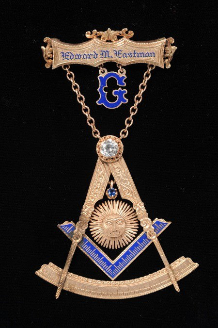 AN ANCIENT FREE & ACCEPTED MASON APRON JEWEL 1933: Remarkable multi-piece construction jewel with gilted pin back brooch and inset blue enamel name, 'Edward M. Eastman,' suspended blue enamel 'G,' chain suspended compass and other emblems with large c