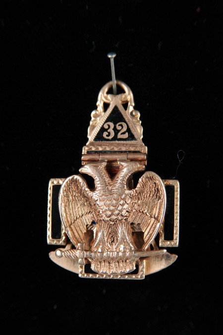 MASONIC GOLD AND ENAMEL PENDANT: Enameled cross base with hinged front and back featuring the double-headed eagle on one side, compass and swan to the other. Gold test positive. Measures 1.25 x 1 inch, weighs .41 troy oz.