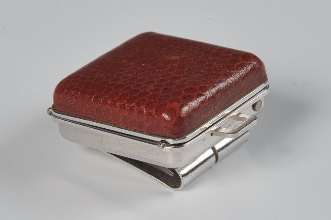 A TIMEX BEN HOGAN GOLF WATCH: Clip-on, brown snake skin-style exterior side. Measures 1.25 inches square when closed. Winds and ticks, running condition not guaranteed.