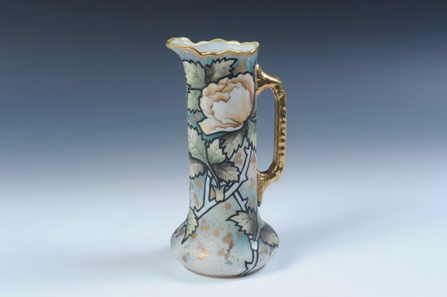 A NORITAKE NIPPON HAND PAINTED TANKARD: Hand painted florals with gold beading, maple leaf mark, measures 9" x 4.5".