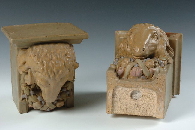 GLAZED TERRA COTTA ARCHITECTURAL RAM'S HEAD POTTERY CAP: A pair of heavy figural ram's head capitals with polychrome glaze on architectural tile material similar to that of Rookwood's architectural items, one is marked 6024B, measures 8 x 6.75 x 7 inches ea