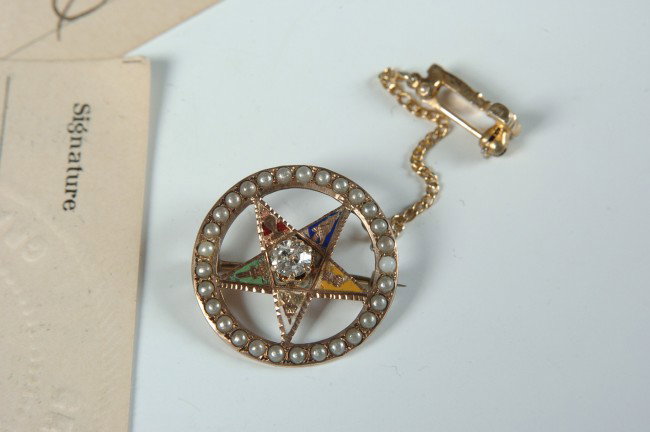MASONIC LAPEL PIN WITH DIAMOND AND HANGER: Masonic pentacle with enameled arms, inset stone in center tested positive for diamond, 3/4 inch diameter, plus chain and small gavel hanger with its own pin. Also includes a set of 11 Order of the Ea