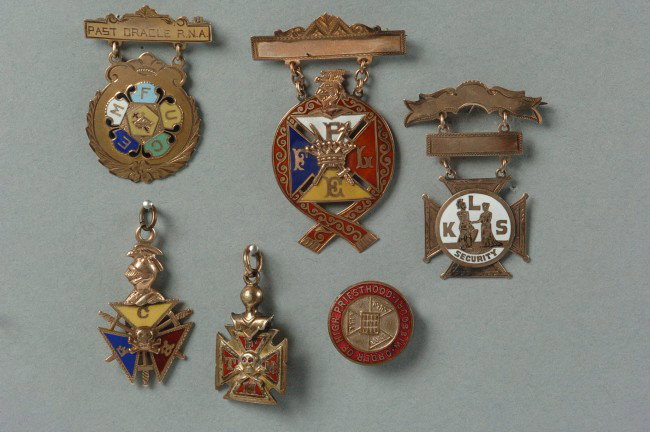 SIX MASONIC AND FRATERNAL BADGES, FOB & LAPEL PIN: Includes three suspended badges with enamel details, FLPE and 'Past Oracle RNA', plus a KLS Security, tow fobs - K of C and FCB, and a Missouri Order of High Priesthood enameled lapel badge, largest m