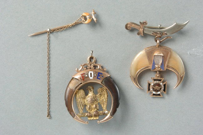 SHRINERS LAPEL BADGE, STICKPIN & FOE CLAWS: Very nice Shriners gilt tipped and trimmed claws with applied pharonic face and suspended enameled 'In Hoc Signo Vinces' pendant, all suspended by scimitar pin brooch. Unmarked. Stickpin with enameled